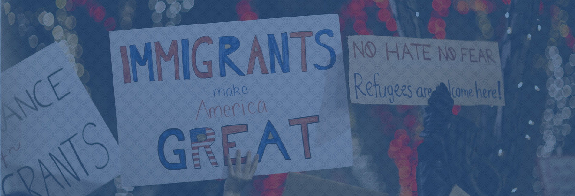 Banner image: protesters carrying pro-immigration and pro-refugee signs